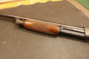 The single action bar can be seen here on the left side of the magazine tube, with the forearm in the forward position.