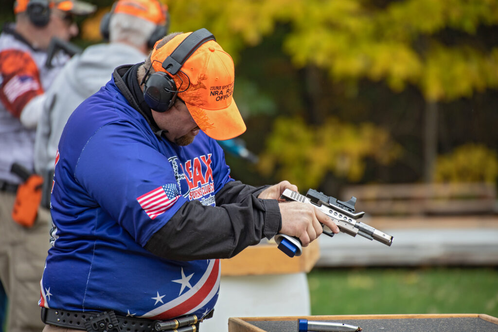 Man clearing a pistol malfunction during a competition.
