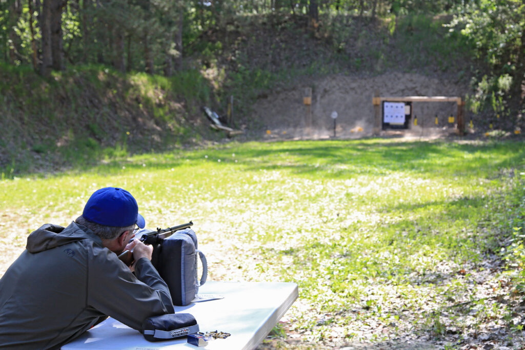 Man at an outdoor range sighting in his rifle.